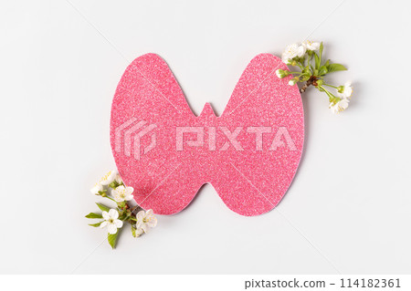 World Thyroid Day. Concept of thyroid disease and health. Pink Paper form of the thyroid gland on gray background with branches of cherry blossoms 114182361