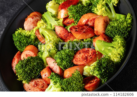 fried juicy sausage and crispy broccoli in skillet 114182606