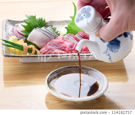 Pouring soy sauce with whale sashimi in the background 114182757