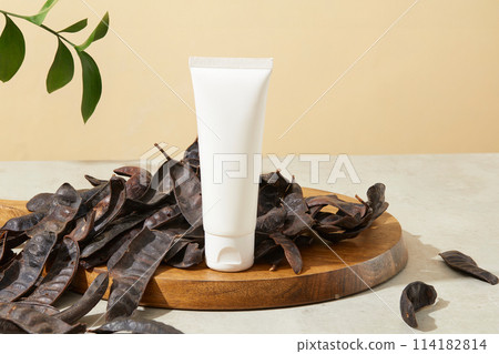 Unlabeled tube standing on cutting board with lots of black locust fruits surrounded. Branding mockup. Black Locust (Fructus Gleditschiae) is rich in vitamins, minerals, and protein Unlabeled tube standing on cutting board with lots of black locust fruits surrounded. Branding mockup. Black Locust (Fructus Gleditschiae) is rich in vitamins, minerals, and protein 114182814