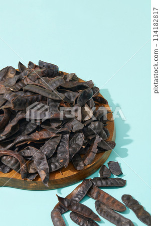 Light blue background features a wooden cutting board with many black locust fruits placed on. Washing your hair with Black Locust can actually improve scalp fungus Light blue background features a wooden cutting board with many black locust fruits placed on. Washing your hair with Black Locust can actually improve scalp fungus 114182817