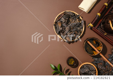 Many black locust fruits placed on bamboo baskets and on the surface. Dipper water scoop displayed with teapot and a teacup. Copy space. Blank space on brown background for product promotion Many black locust fruits placed on bamboo baskets and on the surface. Dipper water scoop displayed with teapot and a teacup. Copy space. Blank space on brown background for product promotion 114182821