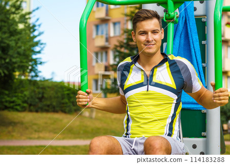 Man flexing arm in outdoor gym 114183288