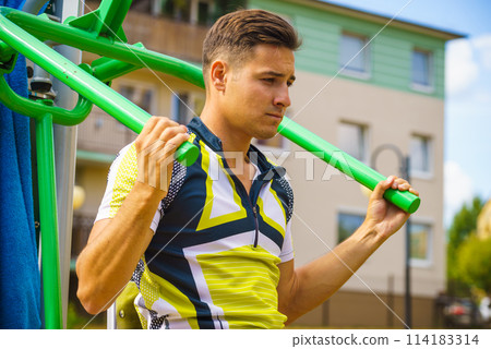 Man flexing arm in outdoor gym 114183314