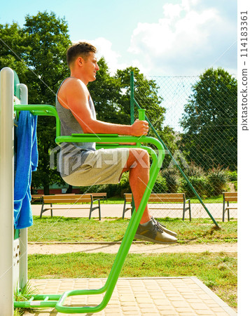 Man doing legs exercises in outdoor gym Man doing legs exercises in outdoor gym 114183361