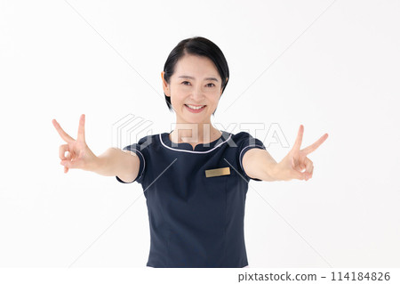 Middle-aged woman, esthetician, uniform, peace sign 114184826