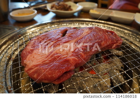 Thick beef grilled directly on a charcoal grill 114186018