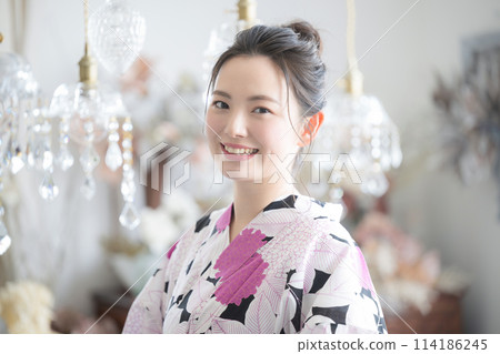 一位年輕女子穿著浴衣,背景美麗閃閃發光 一位年輕女子穿著浴衣,背景美麗閃閃發光 114186245