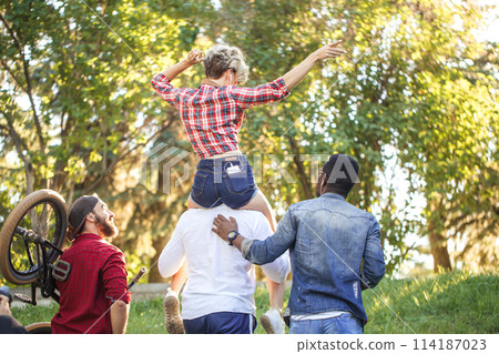 Young coupe in park. Boyfriend carrying his girlfriend on piggyback. 114187023
