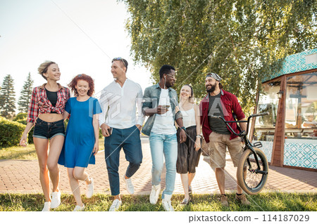 Happy multiethnic friends being glad to be at urban park outdoors Happy multiethnic friends being glad to be at urban park outdoors 114187029