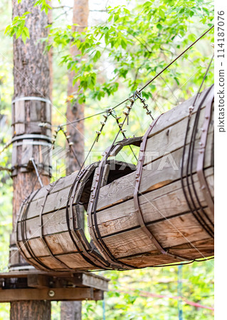 Wooden barrel tunnel obstacle at rope adventure park Wooden barrel tunnel obstacle at rope adventure park 114187076