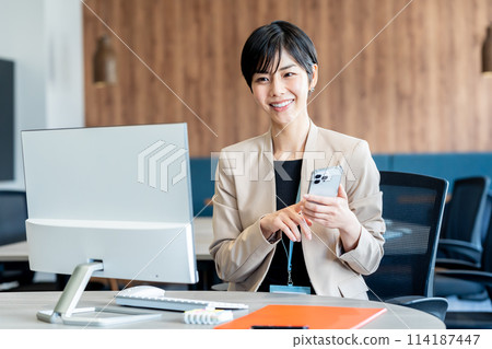 Business woman using a smartphone in the office 114187447