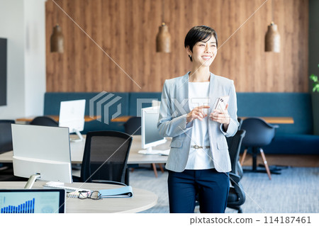 Business woman using a smartphone in the office 114187461