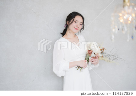 A beautiful woman looks at the camera in the luxury of the sparkling chandelier. Beauty and Bridal A beautiful woman looks at the camera in the luxury of the sparkling chandelier. Beauty and Bridal 114187829