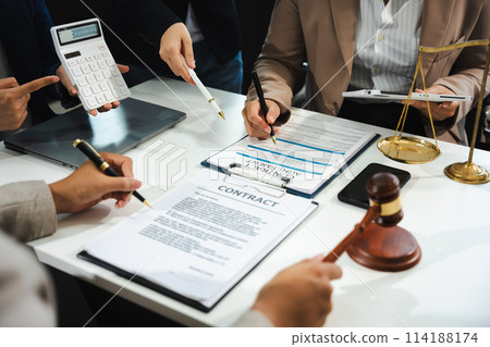 Business people and lawyers discussing contract papers sitting in the table at office in the morning. concepts of law, advice, legal services. Business people and lawyers discussing contract papers sitting in the table at office in the morning. concepts of law, advice, legal services. 114188174