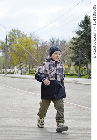 handsome boy runs along the sidewalk while walking handsome boy runs along the sidewalk while walking 114188608