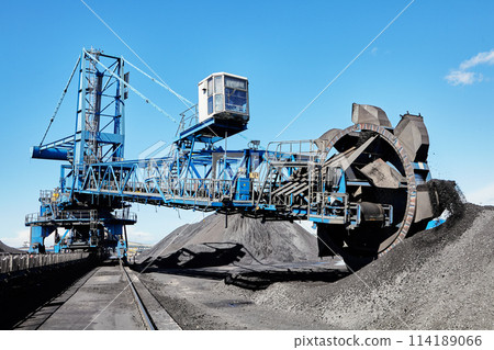 Bucket wheel boom reclaimer dealing with heavy bulk materials in coal stockyard. Bucket wheel boom reclaimer dealing with heavy bulk materials in coal stockyard. 114189066