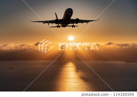 Sunrise over the sea and the silhouette of a jumbo jet Sunrise over the sea and the silhouette of a jumbo jet 114189309