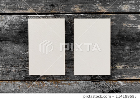Mockup of two white vertical blank business cards at wooden vintage table background. Mockup of two white vertical blank business cards at wooden vintage table background. 114189683