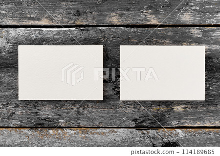 Mockup of two white horizontal blank business cards at wooden vintage table background. 114189685