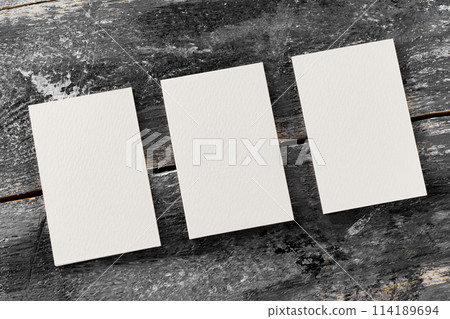 Mockup of three white vertical blank business cards at wooden vintage table background. Mockup of three white vertical blank business cards at wooden vintage table background. 114189694