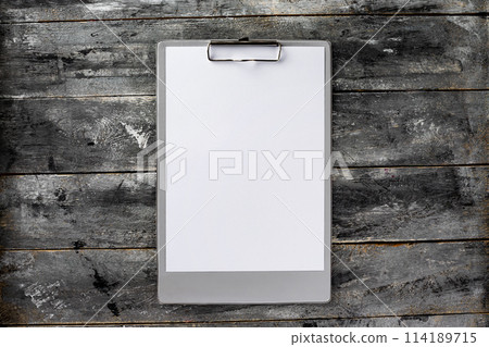 Top view mockup of clipboard and white blank letterhead at wooden vintage table background. Top view mockup of clipboard and white blank letterhead at wooden vintage table background. 114189715