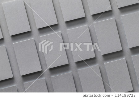 Mockup of vertical business cards stacks arranged in rows at grey textured paper background. 114189722