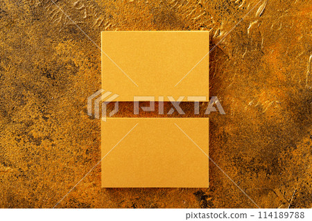 Flatlay mockup of two horizontal golden foil business cards at golden textured luxury background. 114189788