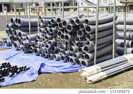 A construction site for a tower apartment building with pipes piled up A construction site for a tower apartment building with pipes piled up 114189870