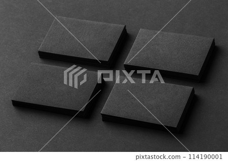 Mockup of four black business cards stacks arranged in rows at black paper background. Mockup of four black business cards stacks arranged in rows at black paper background. 114190001
