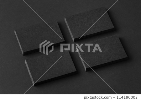 Mockup of four black business cards stacks arranged in rows at black paper background. 114190002