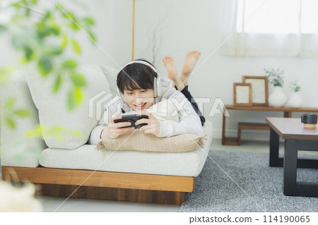 Young man relaxing in the living room Young man relaxing in the living room 114190065