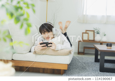 Young man relaxing in the living room Young man relaxing in the living room 114190067