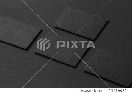 Mockup of four black business cards arranged in rows at black paper background. Mockup of four black business cards arranged in rows at black paper background. 114190224