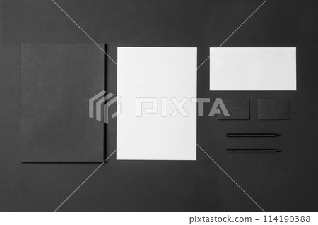 Corporate stationery set mockup. Presentation folder, letterheads and two business cards at black textured paper background. Corporate stationery set mockup. Presentation folder, letterheads and two business cards at black textured paper background. 114190388