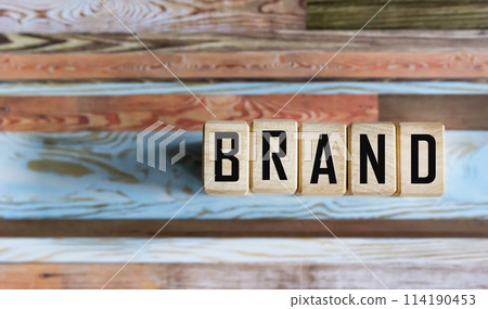 The brand word is written on a wooden block. Brand concept. Isolated on vintage background. 114190453