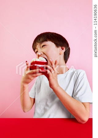 Sweet treat. Boy, kid enjoying delicious red velvet cake with cream and berries, making big bite against pink background Sweet treat. Boy, kid enjoying delicious red velvet cake with cream and berries, making big bite against pink background 114190636