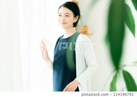 A middle-aged woman bathing in the morning sunlight 114190791