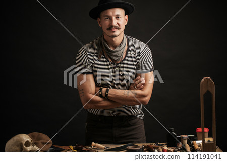 Craftsman posing on his working place with crafting tools Craftsman posing on his working place with crafting tools 114191041