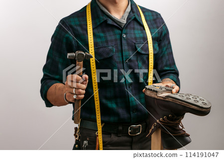 Shoemaker in studio. Unrecognizable shoemaker performs shoes in the studio craft 114191047