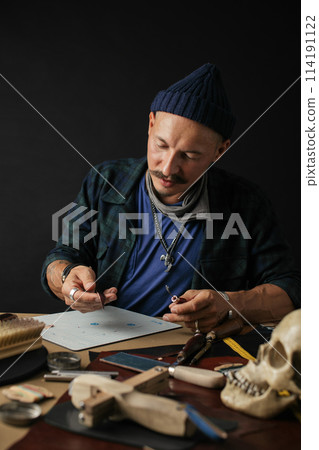 Shoemaker is repairing shoe. Shoemaker sews shoes. Cobbler workshop. 114191122