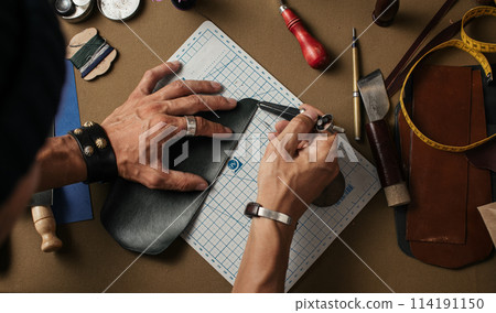 Working process of producing hand made leather wallet in the leather workshop. 114191150