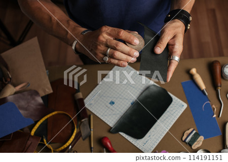 Working process of producing hand made leather wallet in the leather workshop. Working process of producing hand made leather wallet in the leather workshop. 114191151