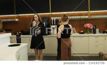 Young attractive women drink water in kitchen interior Young attractive women drink water in kitchen interior 114191730