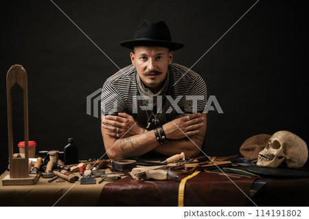 Craftsman posing on his working place with crafting tools 114191802