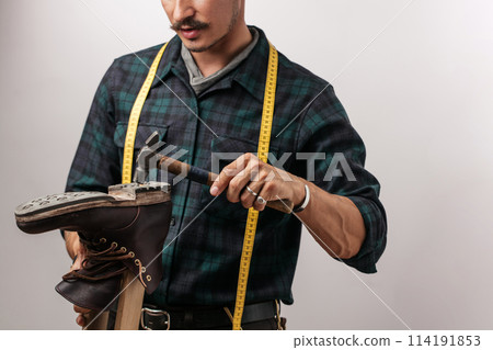 Shoemaker in studio. Unrecognizable shoemaker performs shoes in the studio craft 114191853
