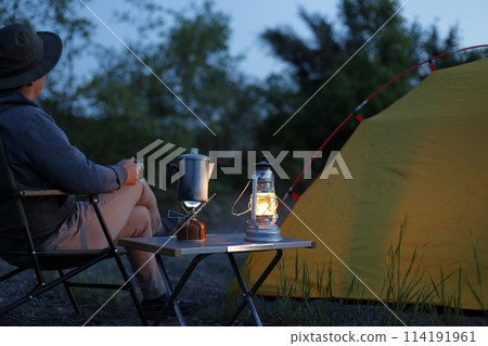 Man enjoying the sunset at camp Man enjoying the sunset at camp 114191961