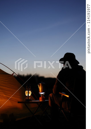 Man enjoying camping at sunset 114191977