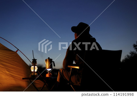 Man enjoying camping at sunset 114191998