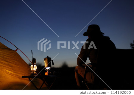 Man enjoying camping at sunset Man enjoying camping at sunset 114192000